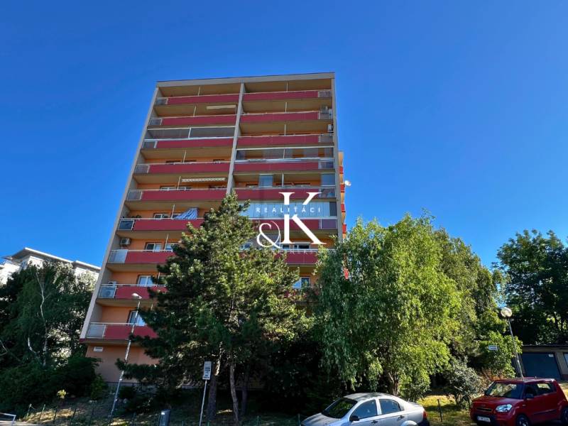High-rise residential building on Ladzianskeho Street, Bratislava - Vinohrady, surrounded by greenery and cars.