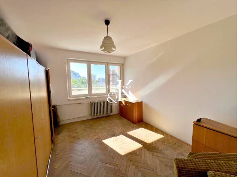A room with built-in wardrobes and parquet floors in a 2-room apartment.