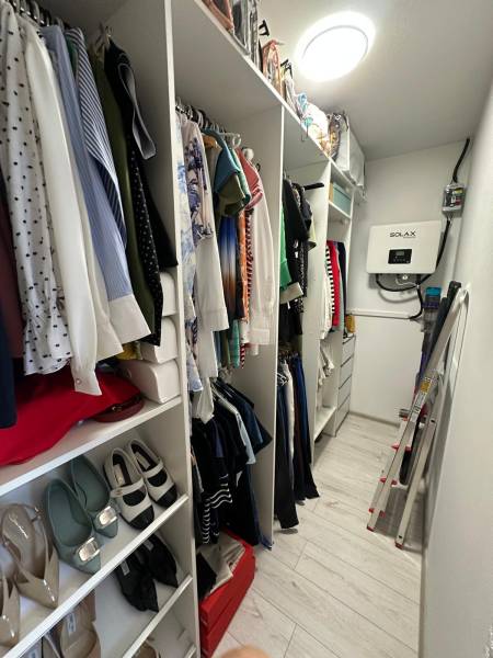 A wardrobe in a family house with clothes, shoes, and storage spaces.