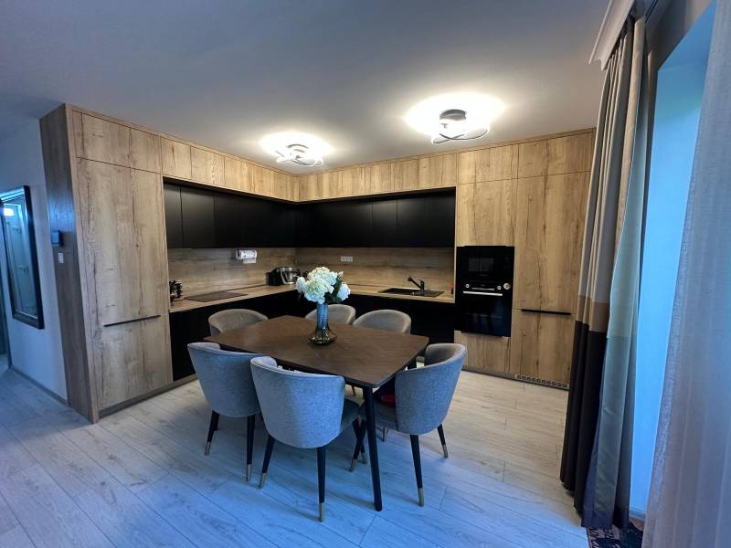 A kitchen in a family house with wooden furniture and a dining table.