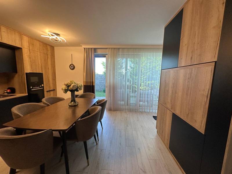 The dining room of a family house with a wooden table and comfortable chairs, view of the garden.