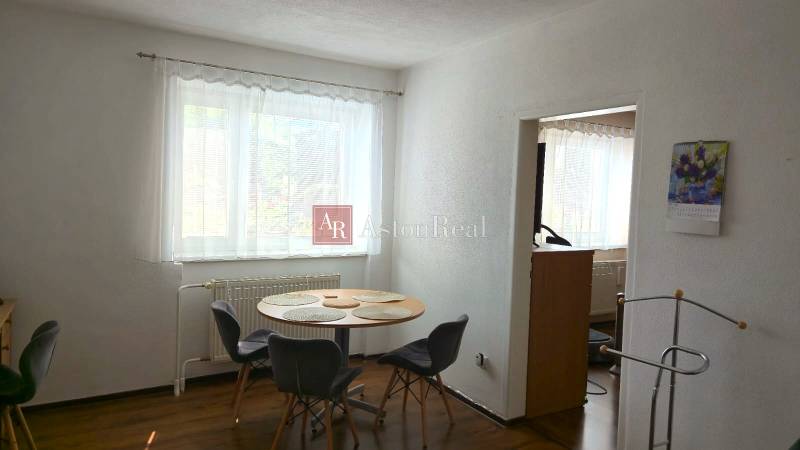 Dining room in a family house with a window, a table and four chairs, white walls.