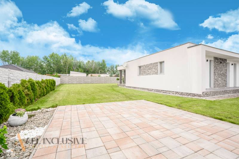 A family house in Dunajský Klátov with a spacious lawn and trees on the property.