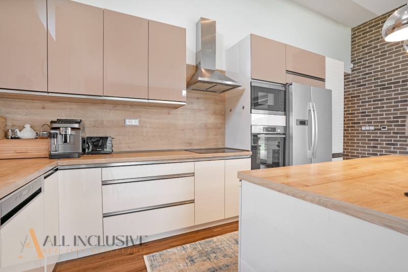 Modern kitchen in a family house with a wooden countertop and appliances.