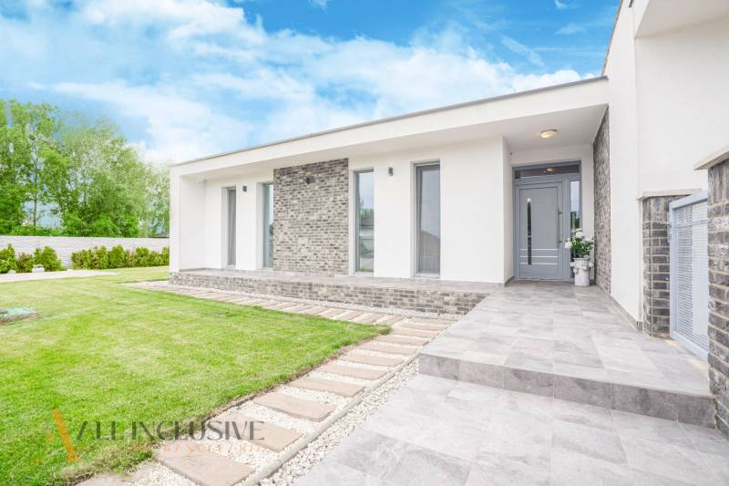 Family house in Dunajský Klátov with a lawn, terrace, and entrance with a walkway.