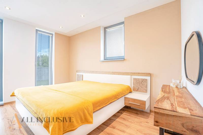 Bright bedroom with wooden floor and yellow blanket in a family house.