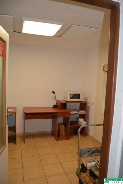 Interior of commercial space with a simple desk and a microwave oven.