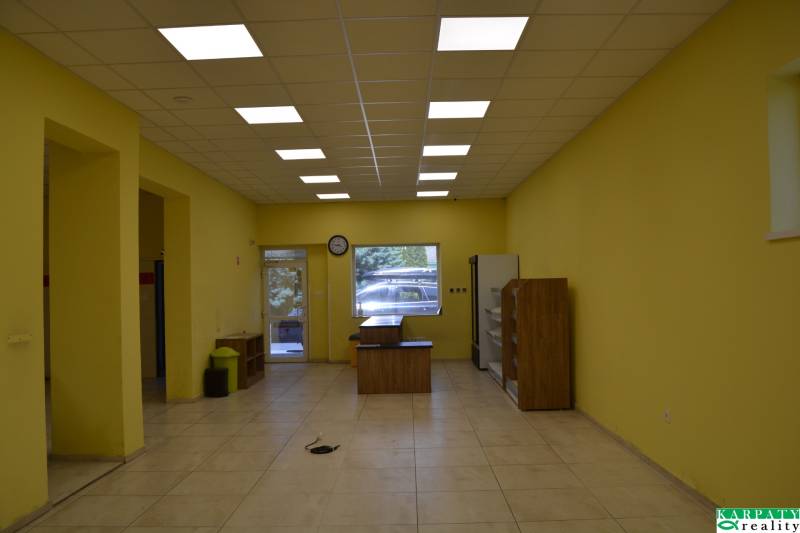 Yellow walls, ceiling lighting, furniture, and entrance doors in commercial premises.