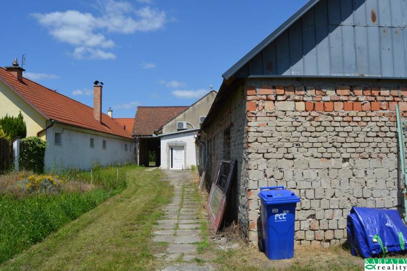Commercial premises in Borský Svätý Jur, buildings with red roofs, lawn, and a blue container.