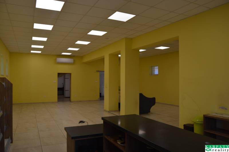 Interior of commercial spaces with a striking yellow wall and ceiling lights.