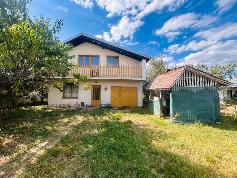 A family house in Sobrance with a garden and an outbuilding under the blue sky.