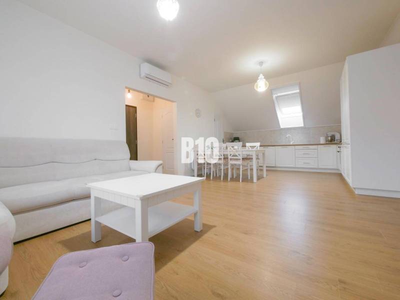 Living room with kitchen in a 3-room apartment, bright space with furniture and wooden floor.