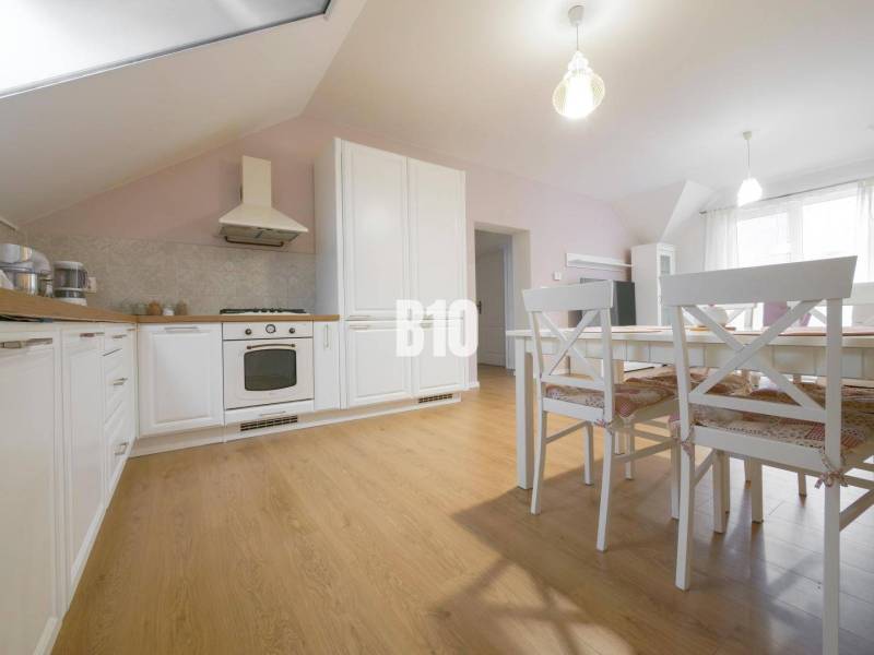 Open kitchen with a dining table in a 3-room apartment, light wooden floors.