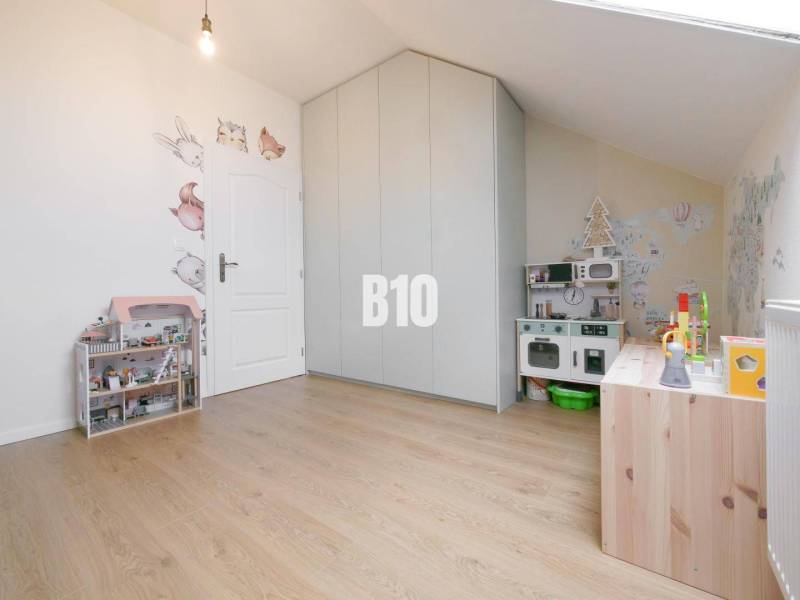 Children's room in a 3-room apartment with a wardrobe, toys, and decorative wallpaper with animals.