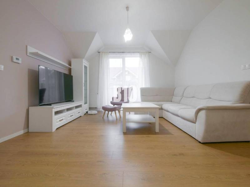 A bright living area in a 3-room apartment with a television and a comfortable sofa.