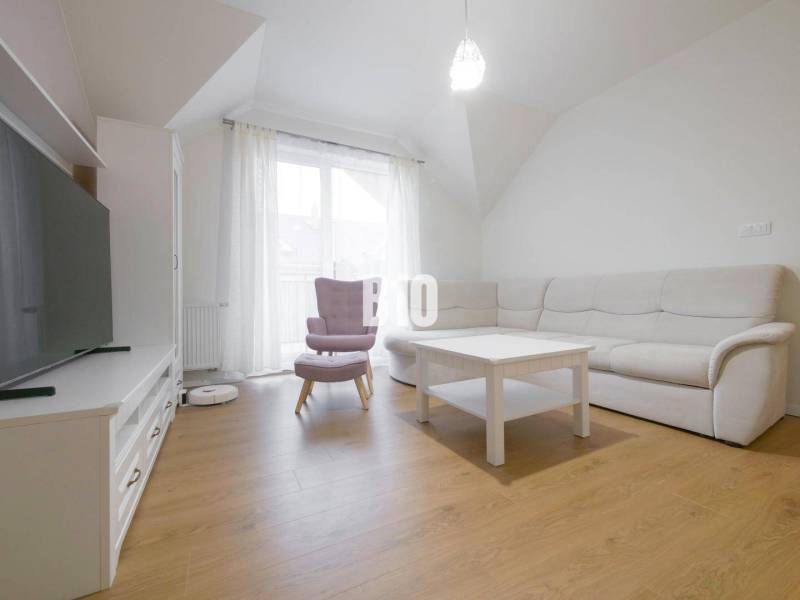 Living room in a 3-room apartment with a sofa, an armchair, a table, and a television.