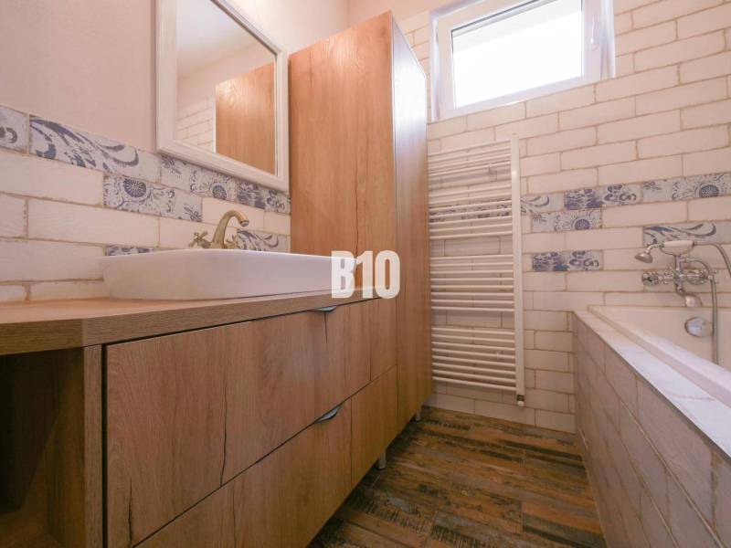Bathroom in a 3-room apartment with wooden furniture and decorative tiles.