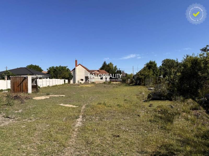 Plots - housing in Veľký Meder with grassy area and nearby buildings.