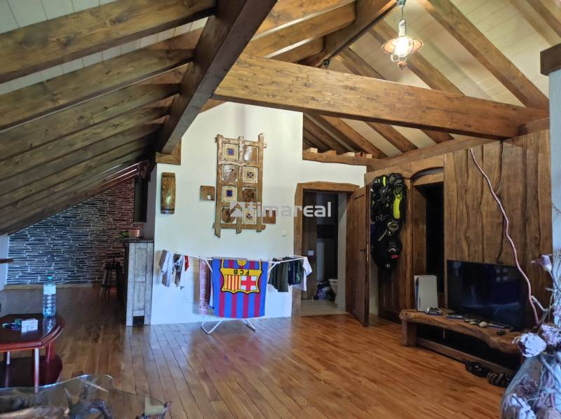 Wooden beams and flooring in a 2-room apartment with a relaxing interior, masks on the wall.