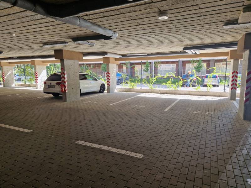 An underground parking lot with a white car.