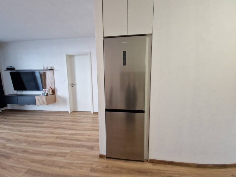 In the 2-room apartment, you can see the kitchen area with a refrigerator and the living room area with a television.