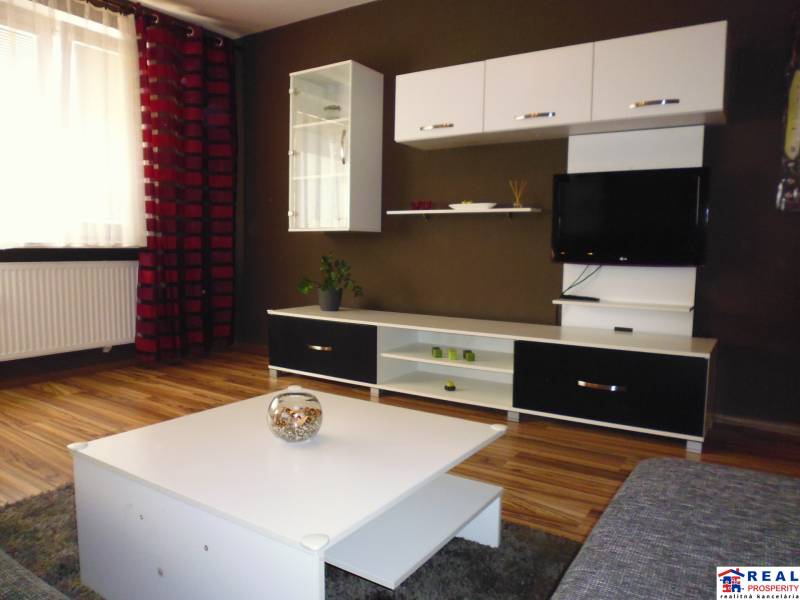 Living room in a three-room apartment with a furniture wall and decorations on the shelves.