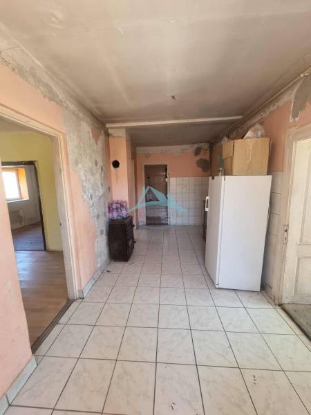 A hallway in a family house with older furnishings and appliances, in need of renovation.