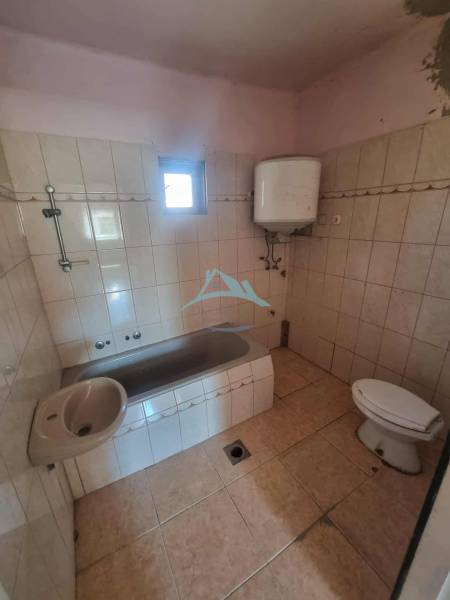 A bathroom in a family house with a bathtub, sink, toilet, and boiler.
