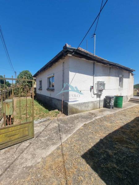 A family house in Ipolyvec with an old roof, a cloudy sidewalk, and electrical wiring.
