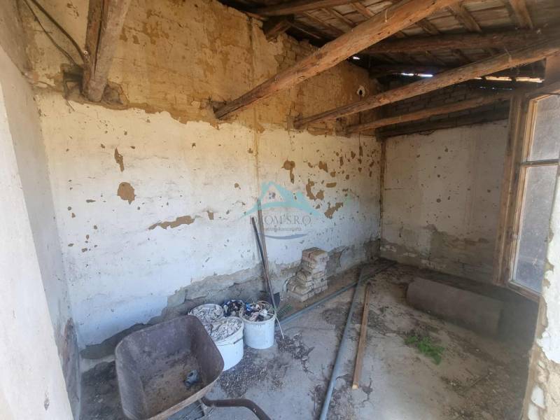 The interior of a family house with damaged walls and old construction equipment.