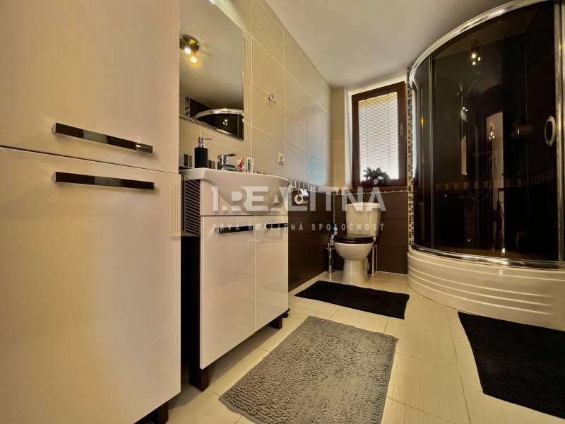 Bathroom in a family house with a bathtub, sink, and storage space.