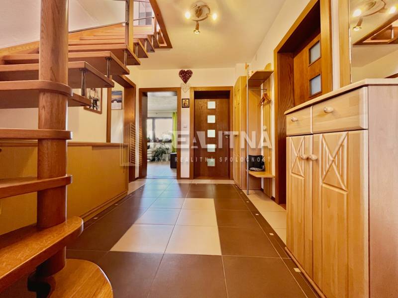 Interior of a family house with a wooden staircase and a modern entrance.