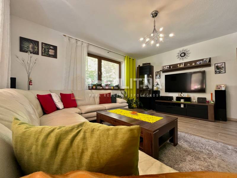 A living room in a family house with a comfortable sofa and a television on the wall.