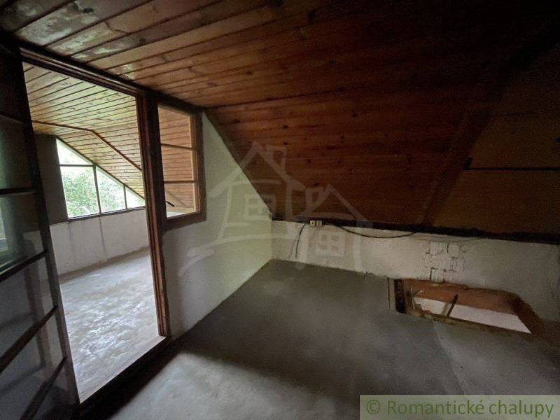 Attic room with wooden paneling and a glass wall in a family house.