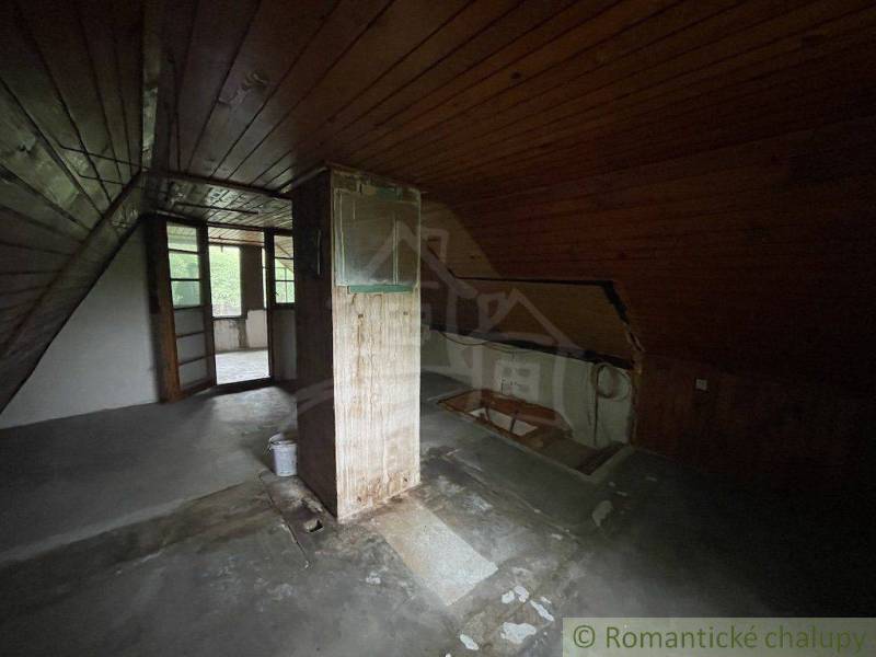 Attic room with wooden walls and floor in a family house.