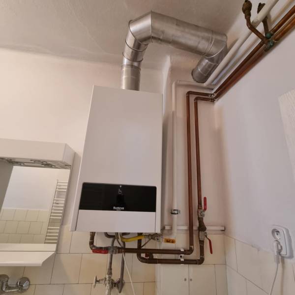 A gas boiler with connected pipes in the interior of a family house.
