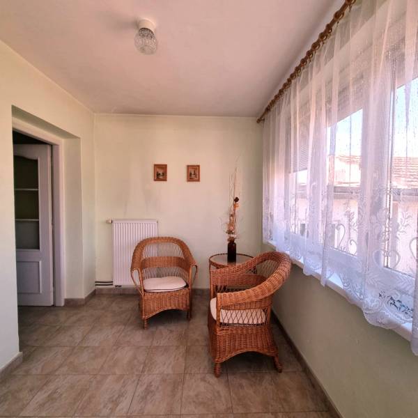 A spacious room in a family house with wicker furniture and elegant curtains.