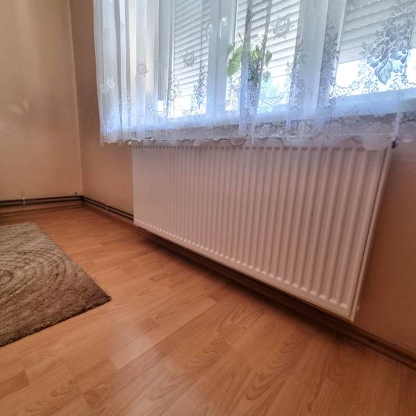 A room with a radiator under the window and a curtain in a family house.