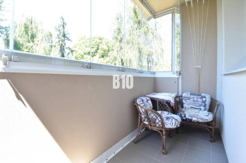 Glazed balcony with two chairs in a 3-room apartment with a nice view.
