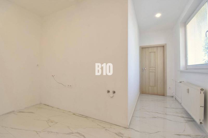 White wall and tiled floor in a 3-room apartment, empty room.