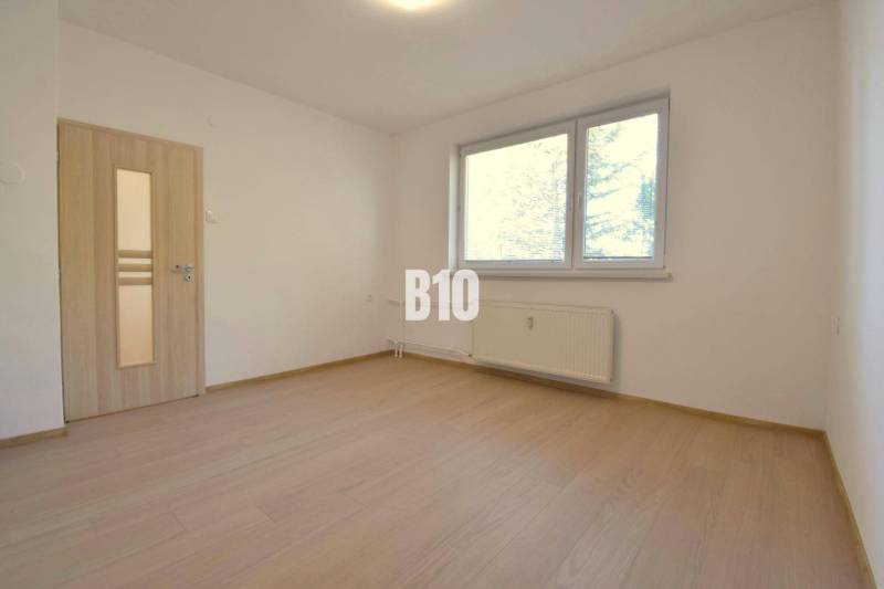 A bright room with wooden floors and a window in a 3-room apartment.