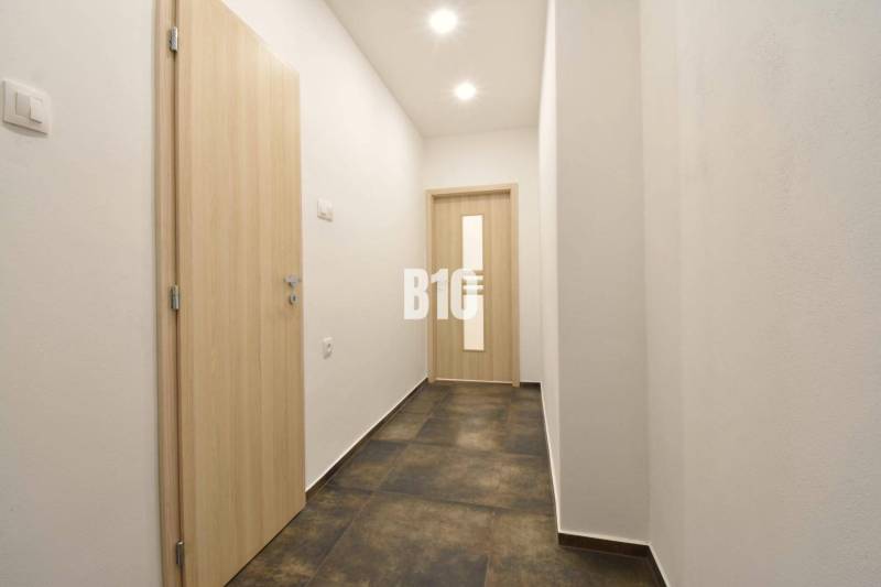 A corridor with white walls and doors in a 3-room apartment.