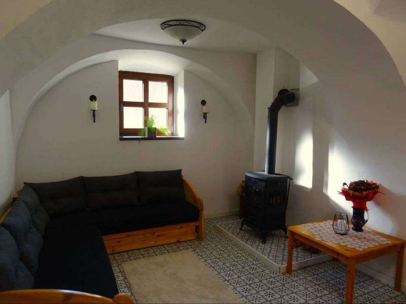 Interior of a family house with a sofa, stove, and decorative table.