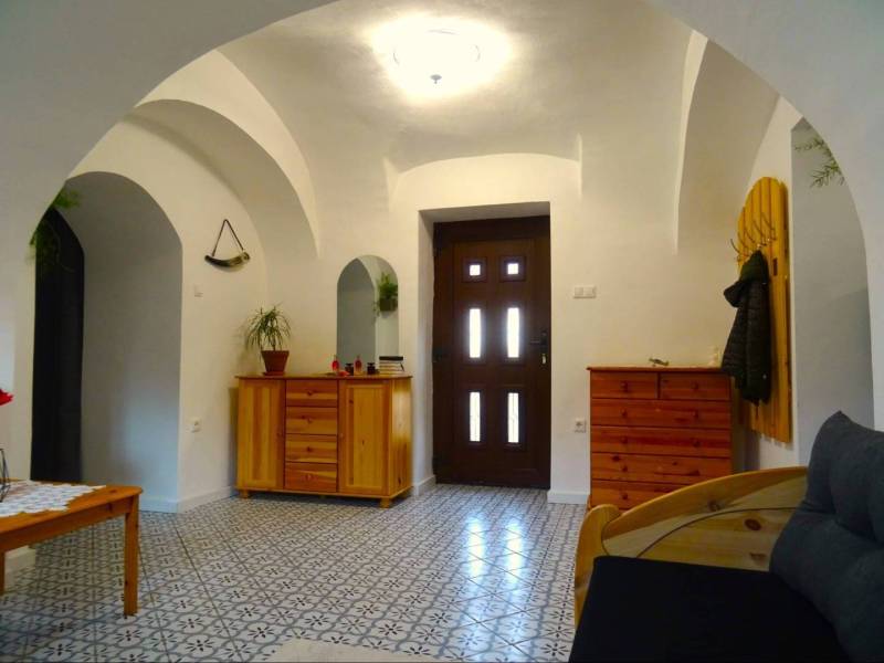 Interior of a family house with arched ceilings, wooden furniture, and patterned flooring.