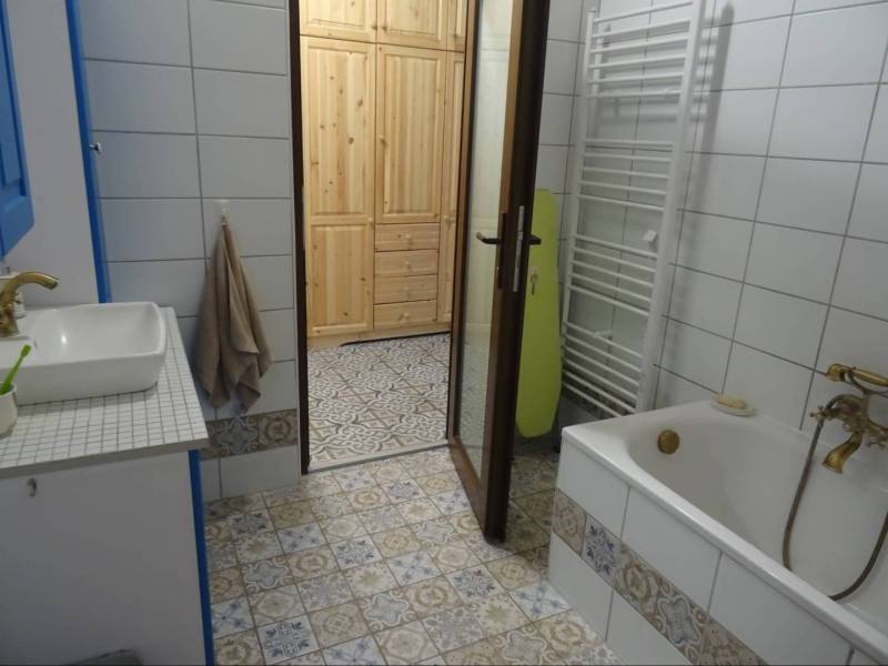 A family house bathroom with a bathtub, a sink, and patterned tiles.