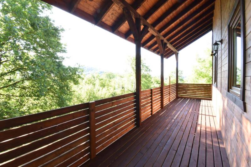 Wooden terrace of the cottage in Bytča with a view of the surrounding greenery.