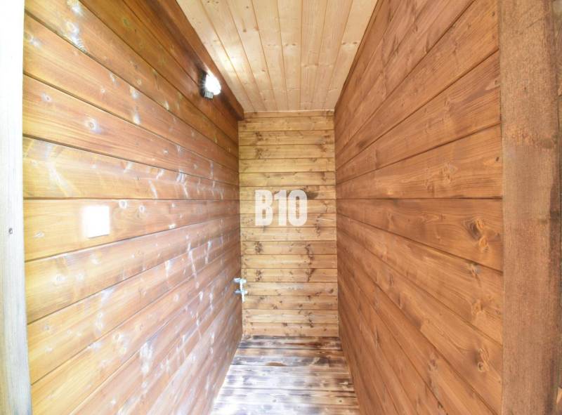 Wooden interior with wall lighting and wooden flooring in a cabin.