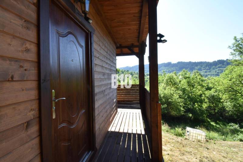 A cottage near Bytča with a wooden terrace surrounded by green nature and forests.