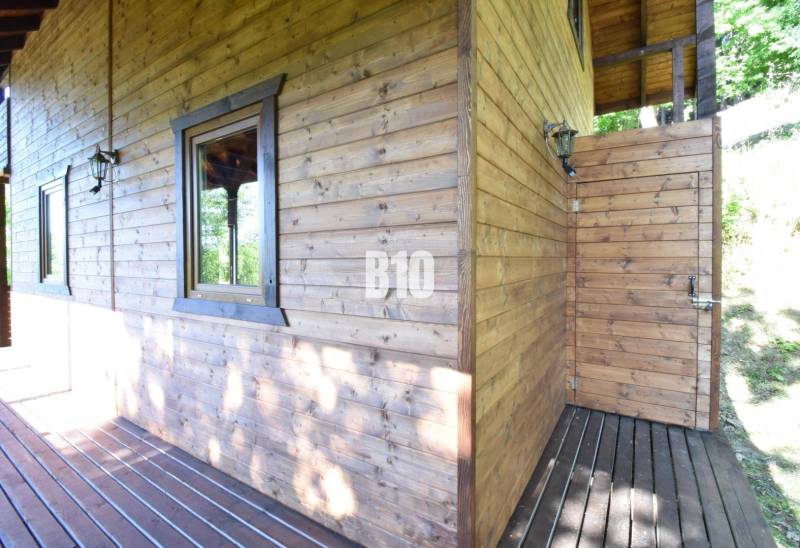 A wooden cottage with a terrace in Bytča, surrounded by nature and sunlight.
