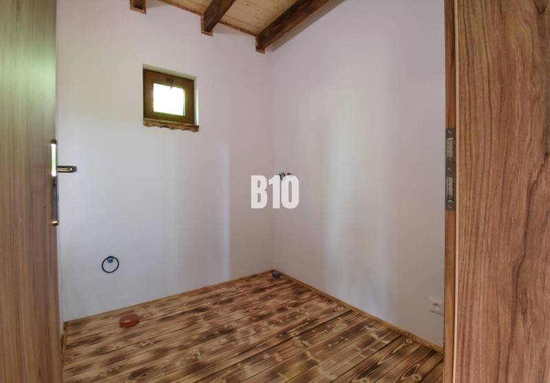Wooden floor and doors in the interior of a cabin with a skylight.